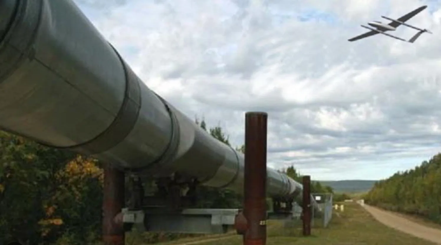 Fixed-wing drone flying along an above-ground pipeline