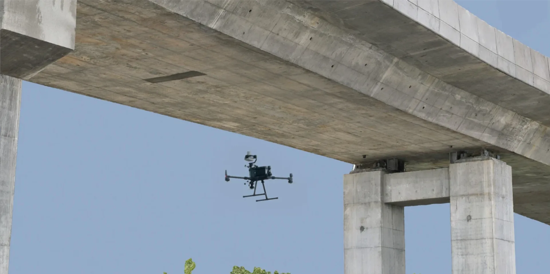 Drone inspecting the underside of a concrete bridge